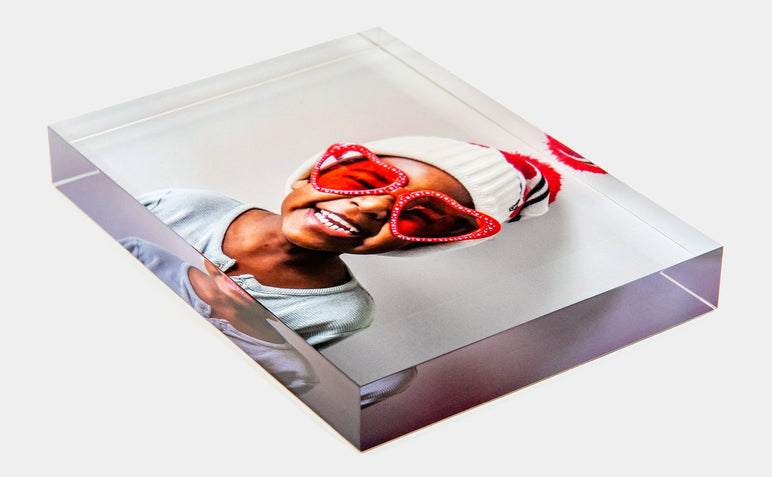 Angled shot of a 5x7" Acrylic Block featuring a photo of a child in heart shaped sunglasses.