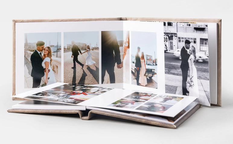 Two Album99s, one laid flat and the other standing behind it. The standing Album99 features wedding photos.
