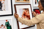 Close up image of a woman hanging an Espresso Framed Print