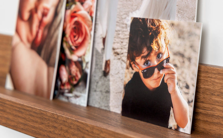 Four photo prints mounted on Single Weight Matboard styled on a photo ledge. The focus image is 4x4" and features a child wearing sunglasses.
