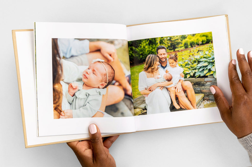 Overhead shot of a 8x8" Hardcover Photo Book with a beige cloth cover featuring photos of a family and their new baby. 
