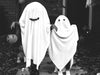 Two kids dressed as ghosts on Halloween