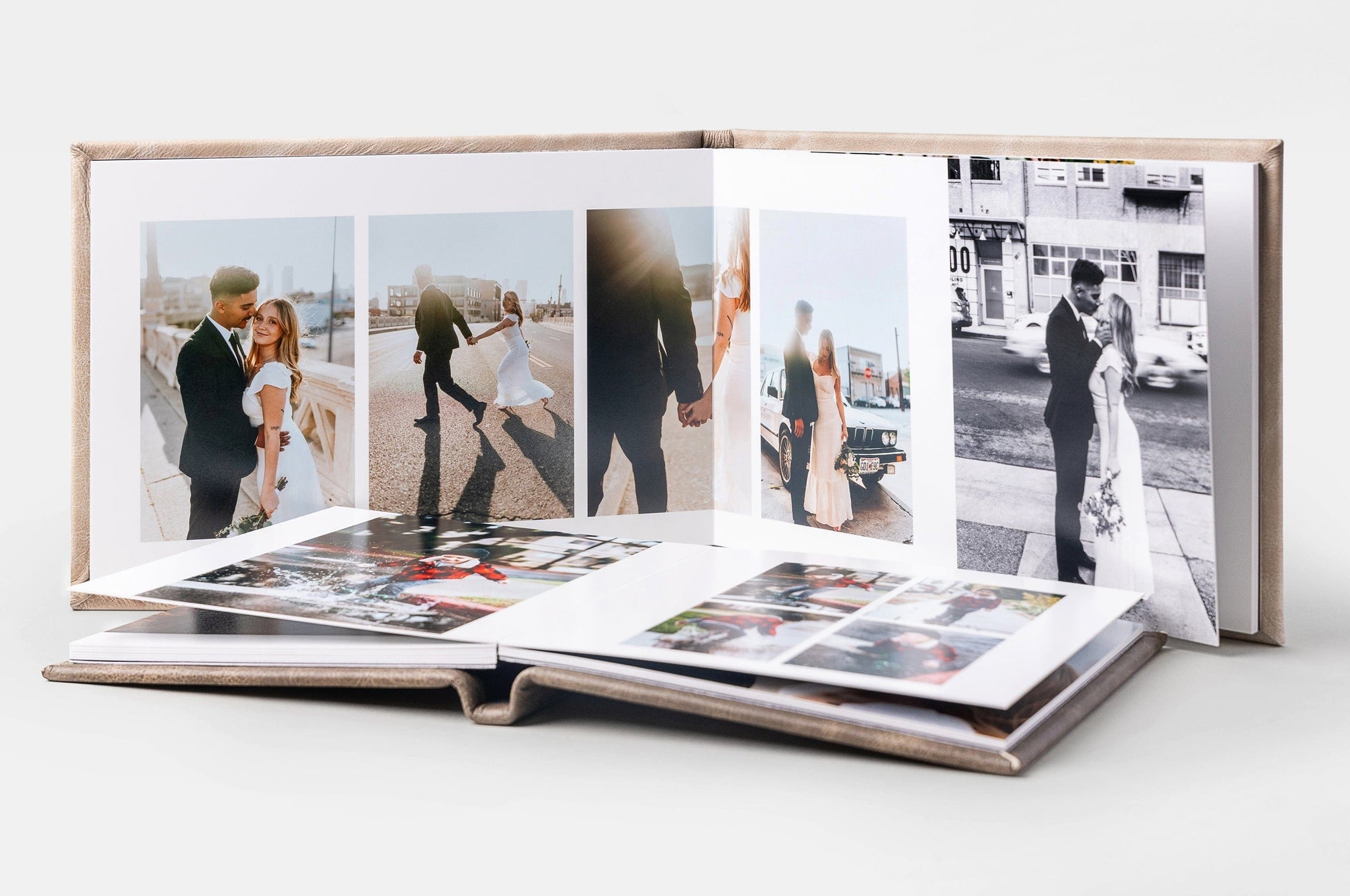 Two Album99s, one laid flat and the other standing behind it. The standing Album99 features wedding photos.