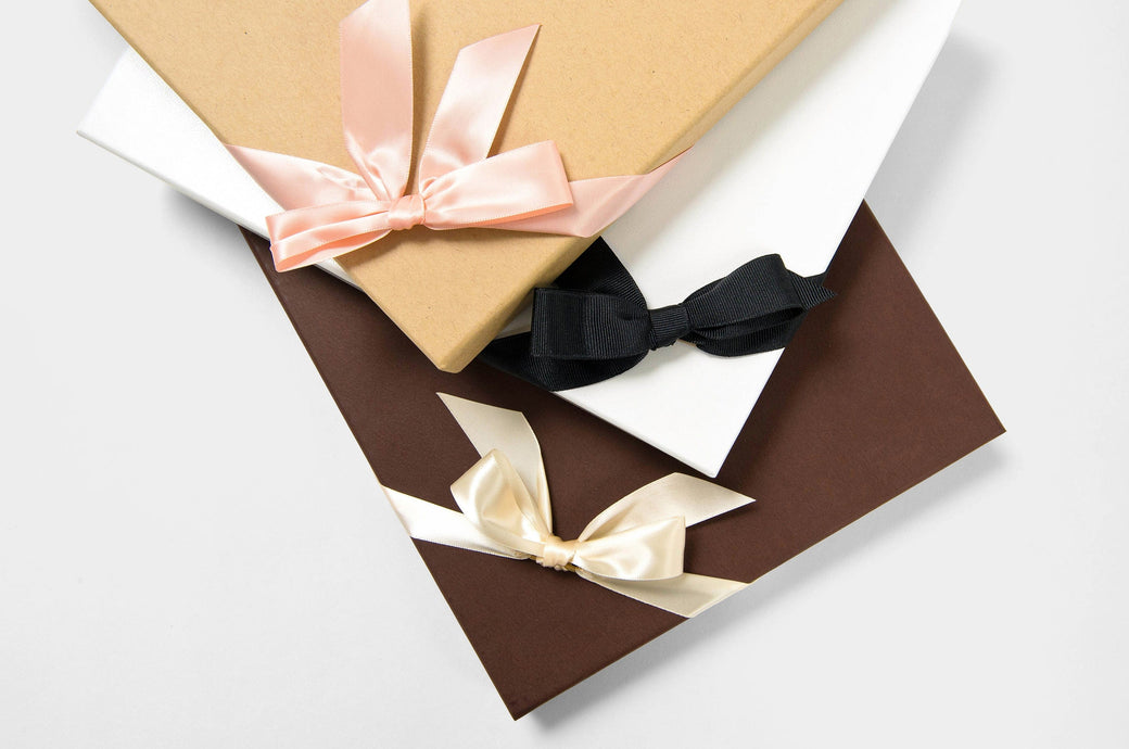 Premium Photo  Three gifts in beige wrapping paper tied with brown ribbons  on brown