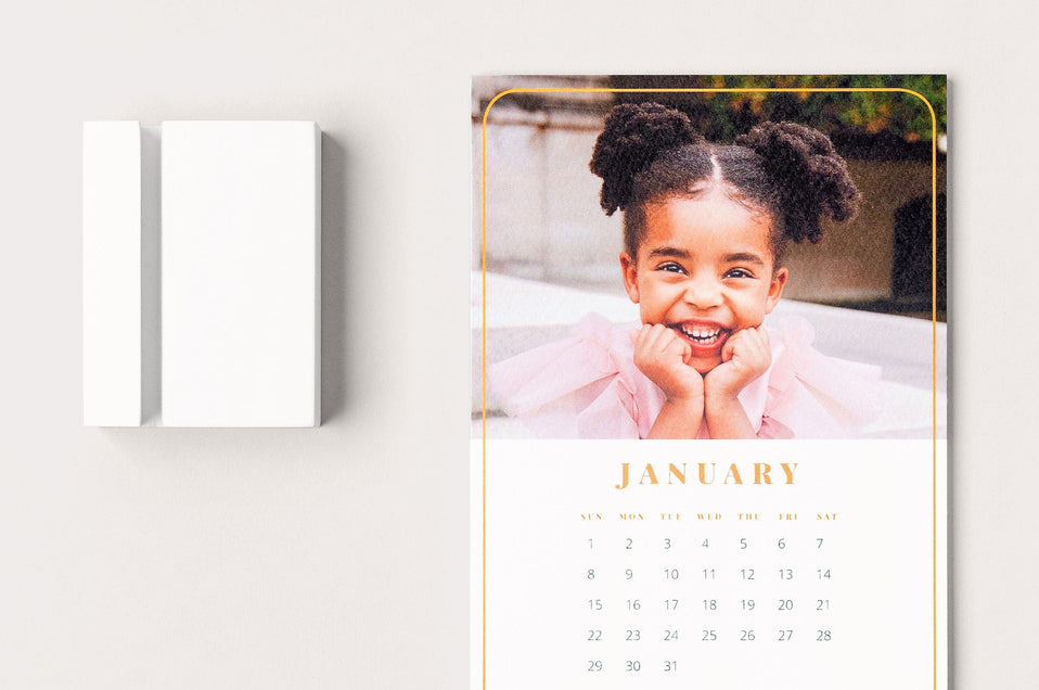Detail shot of a Desk Calendar next to its white block. 