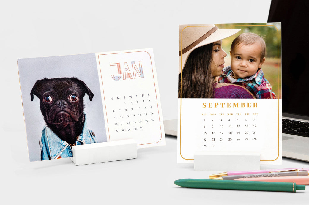 Two Desk Calendars: one landscape Desk Calendar with a picture of a dog and one portrait Desk Calendar with a woman and a baby.