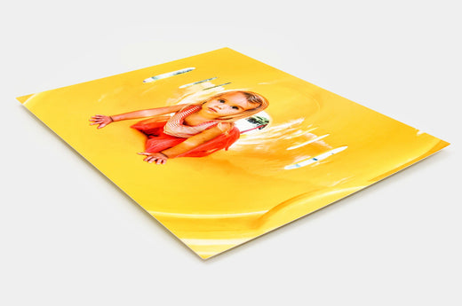 Angled shot of a 16x20" Metal Print with a photo of a young girl on it. 