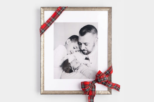 Gallery wall of several, difference sized Wood Framed Prints on a white wall. The Framed Prints feature wintery photos of families, children, and newlyweds - Nations Photo Lab
