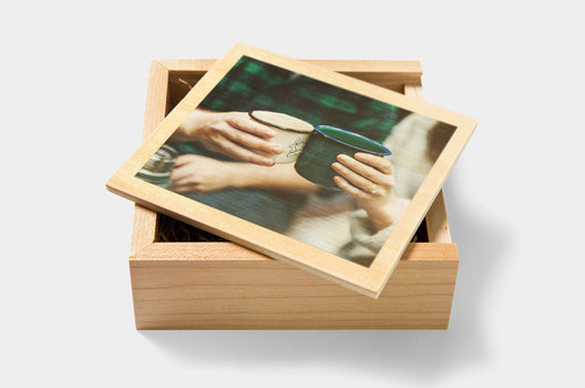 Two people clinking camp mugs on the cover of a custom Wooden USB Box - Nations Photo Lab