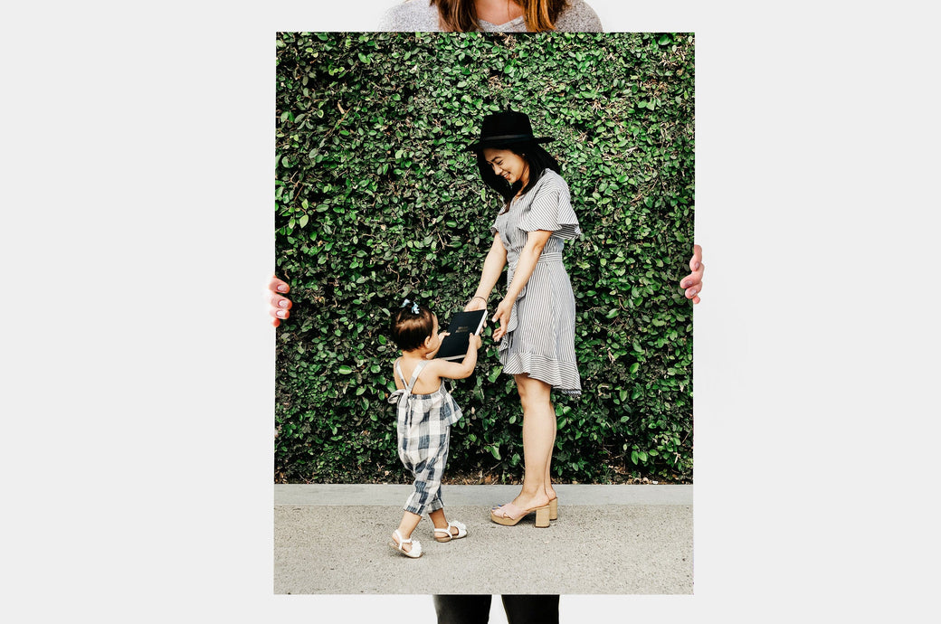 Woman holding a 24x36" Photo Print featuring a picture of a mother and child.