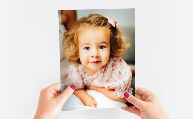 Woman's hands holding a 8x10" Lustre Photo Print featuring a picture of a little girl.