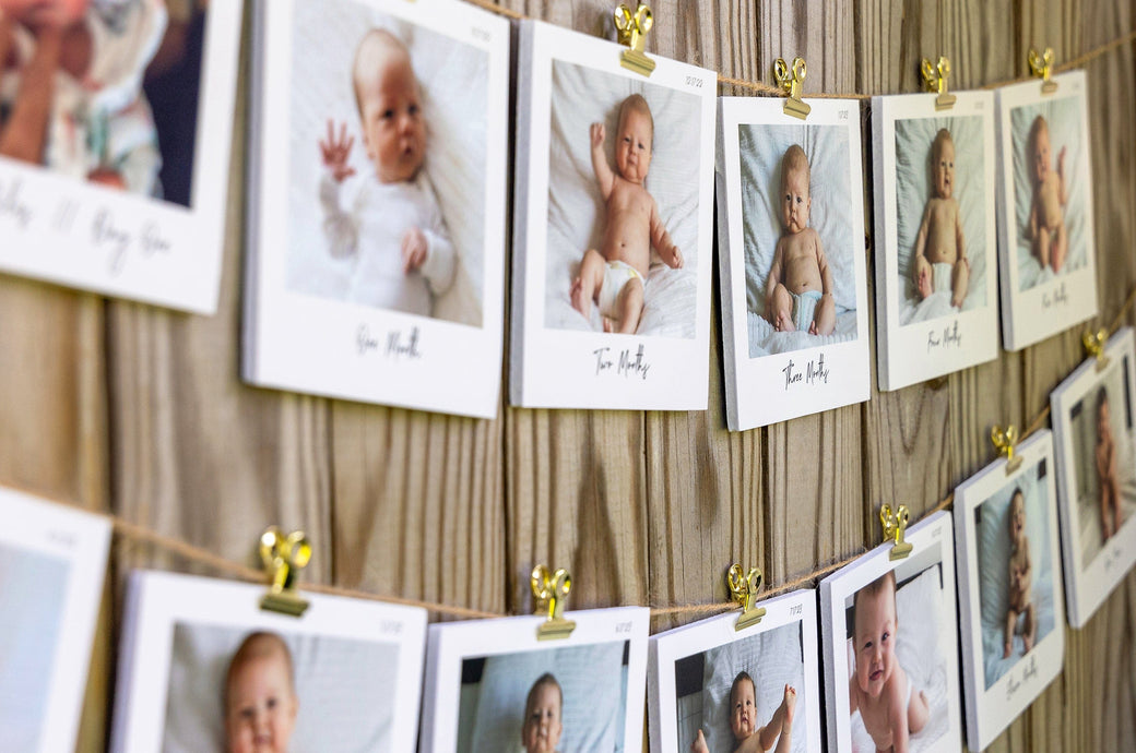 Set of 5x5" Photo Prints mounted on Foamcore and strung along a fence with twine and bullclips. Prints feature photos of a Baby's First Year, one photo for each month of the year.