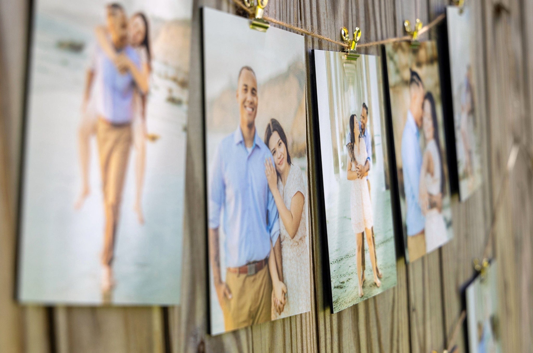 Set of 5x7" Photo Prints mounted on Styrene and strung along a fence with twine and bullclips. Prints feature photos of an engagement shoot. 