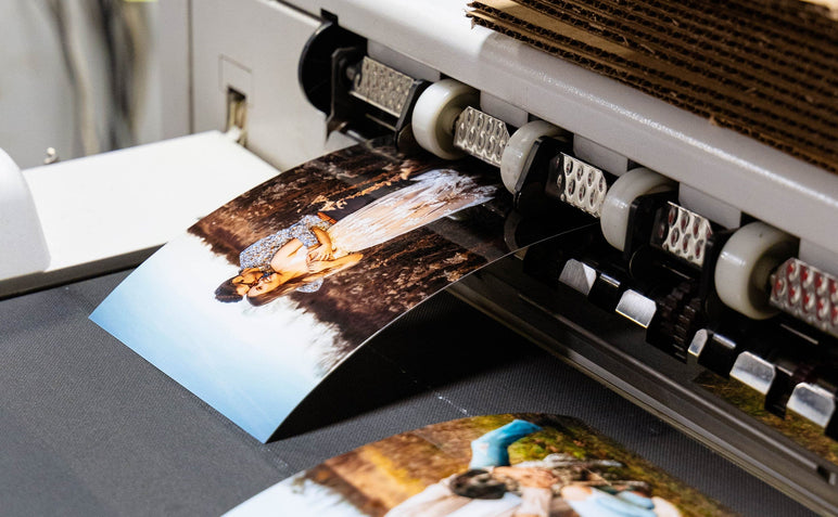 Two Photo Prints featuring engagement pictures coming out of a printer.