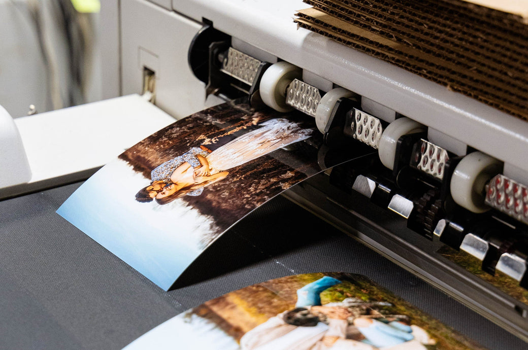 Two Photo Prints featuring engagement pictures coming out of a printer.