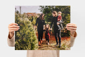 Woman holding up a 16x20" Landscape Lustre Photo Print with a picture of a family in a Christmas tree farm - Nations Photo Lab