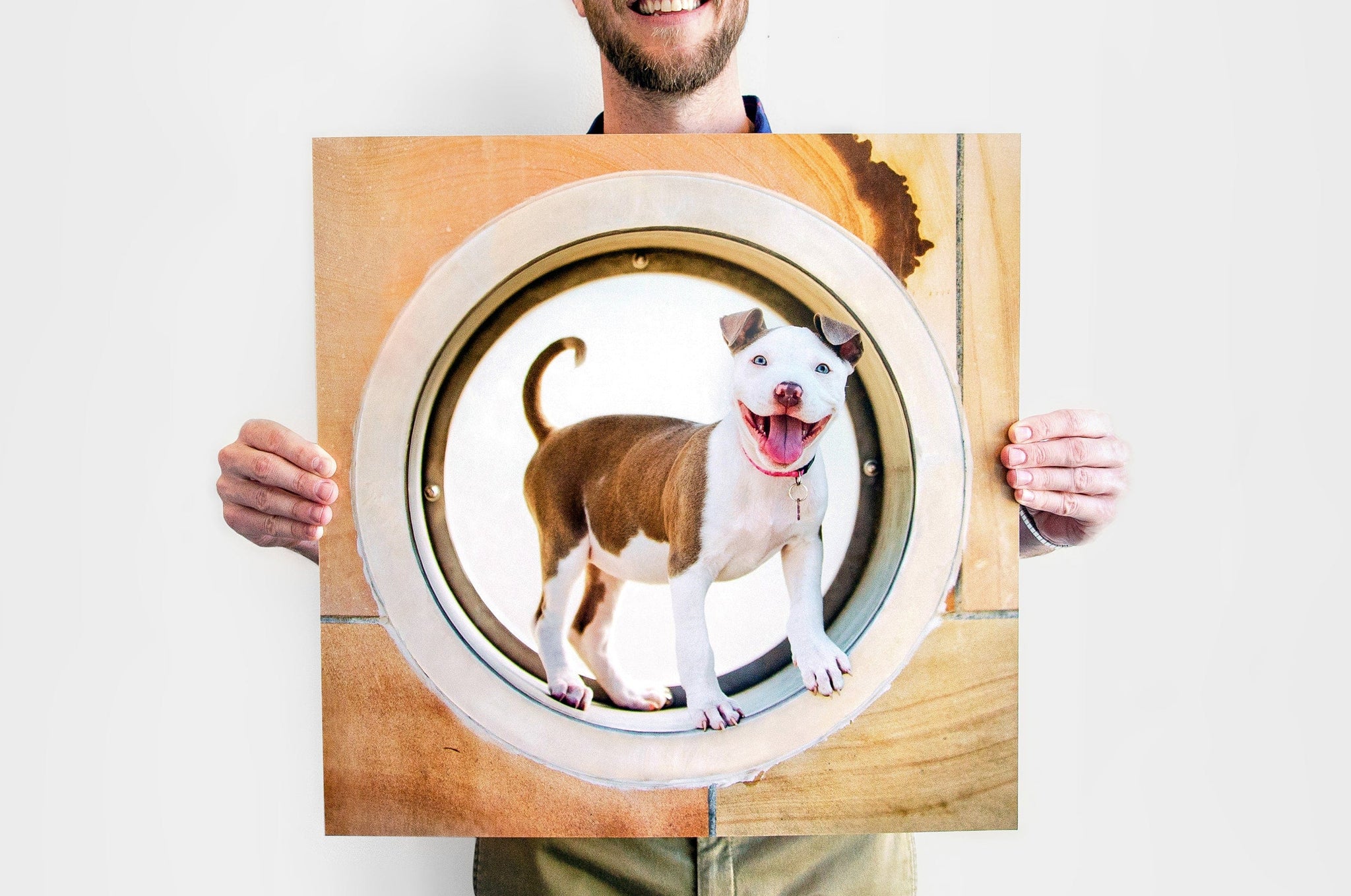 24x24" Square Photo Print being held up by a man. The Photo Print features a picture of a happy looking dog.