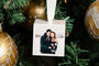 Couple in the snow with their pet dog on a Custom Cube Ornament hanging on a Christmas Tree